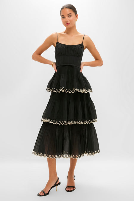 Model wearing the classic Black Embroidered Tiered Midi Dress, featuring an effortless corset bodice, tiered pleated skirt, and fun scalloped trims, embodying high-end sophistication.