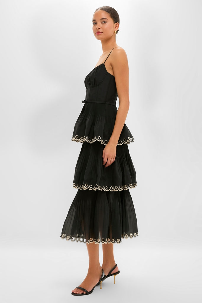 Black Embroidered Tiered Midi Dress on model, showcasing classic, effortless style with adjustable straps, corset bodice, and scalloped trim, paired with fun, high-end slingback sandals.