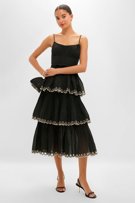Model wearing the classic Black Embroidered Tiered Midi Dress with scalloped trim, accessorized with gold jewelry, embodying an effortless and high-end style.