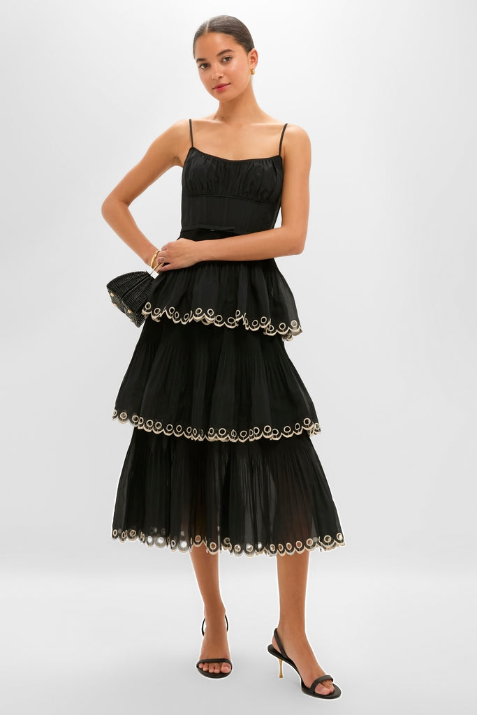 Model wearing the classic Black Embroidered Tiered Midi Dress with scalloped trim, accessorized with gold jewelry, embodying an effortless and high-end style.