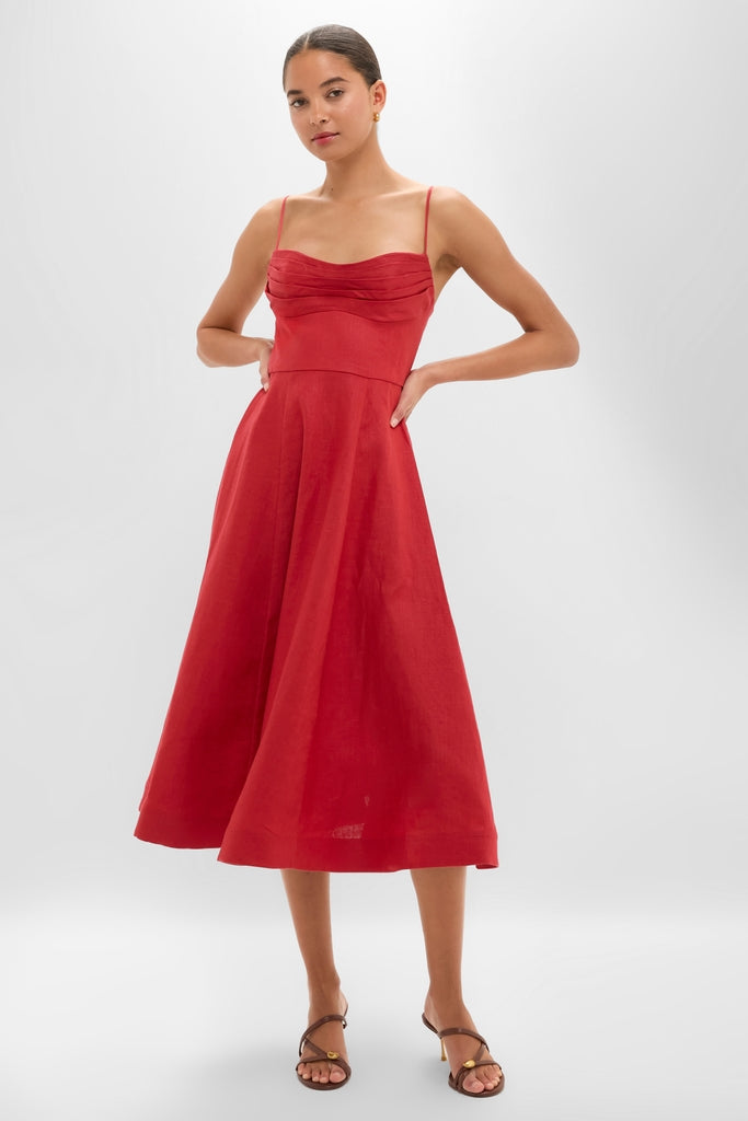 Model wearing the classic Red Rebellion Tuck Midi Dress with elegant drape detailing and A-line skirt, styled with effortless brown heeled sandals for a high-end, fun look.