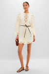 Model in Cream Awaken Embroidered Tunic with lace details, keyhole neckline, billowed sleeves, leather belt, clutch, and sandals. Classic, effortless, high-end style.