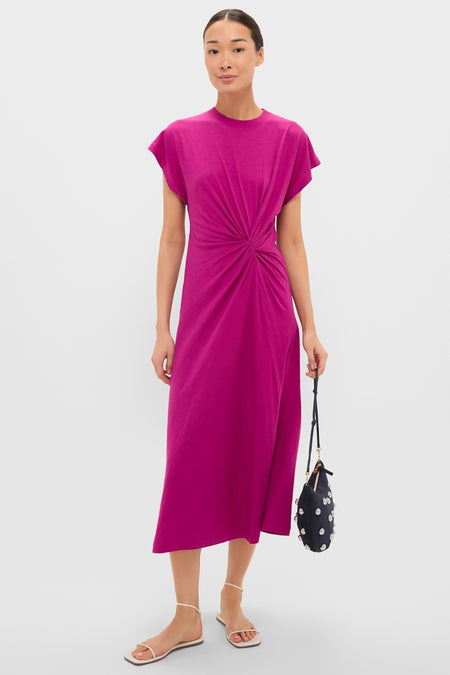 Model in a fuchsia dress holds the classic Navy Suede Lune Bag, adorned with floral appliqués, pairing it with effortless white sandals for a fun, high-end look.