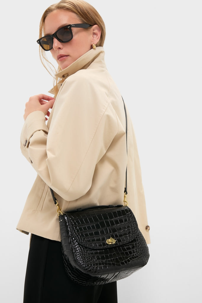 Model showcasing the Black Croco Turnlock Louis with Top Handle, a classic and high-end crossbody bag with gold-tone hardware, embodying an effortless and fun style.