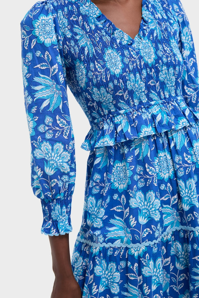 Ink Jaal Mia Dress features a classic, effortless blue floral-print with a smocked bodice, peplum ruffle, and tiered skirt, embodying fun, high-end style.
