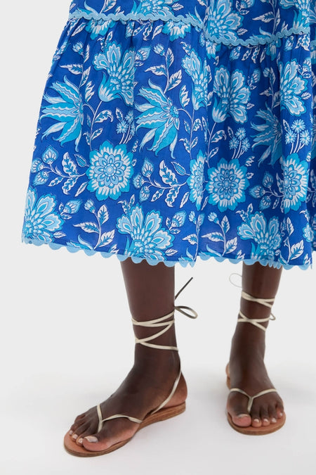 Ink Jaal Mia Dress: A classic, knee-length, tiered skirt with an effortless, high-end floral design, paired with fun, neutral wrap-around sandals, embodying easy sophistication.