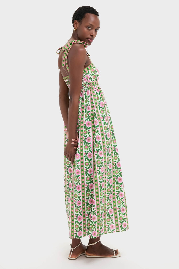 Emerald Border Mykonos Dress: A classic, sleeveless sundress with floral print and bow-tied straps, paired with effortless white-strap sandals, embodying a fun, high-end style.