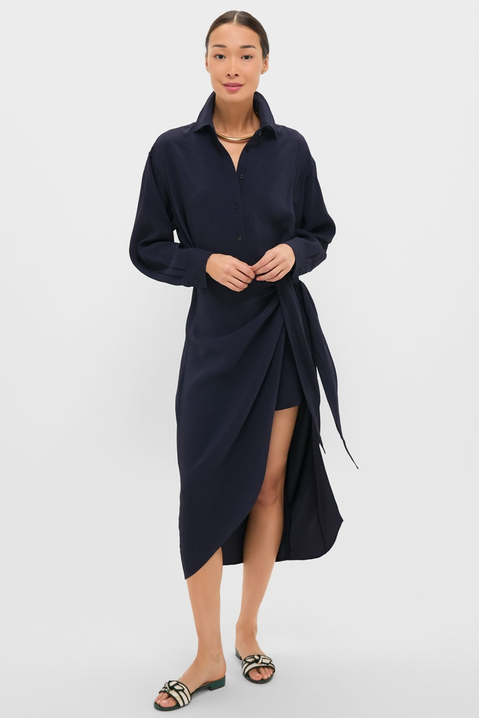 Woman models the classic Midnight Alessandra Sarong Shirt Dress, featuring a side wrap and mid-calf drape, accessorized with a chunky gold necklace for an effortless, high-end style.