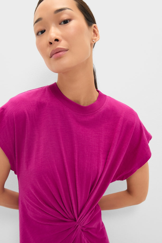 Adult woman models the Fuchsia Volta Twist Dress, an effortlessly classic T-shirt style with a fun waist knot detail, epitomizing Tuckernuck's high-end, confident fashion ethos.