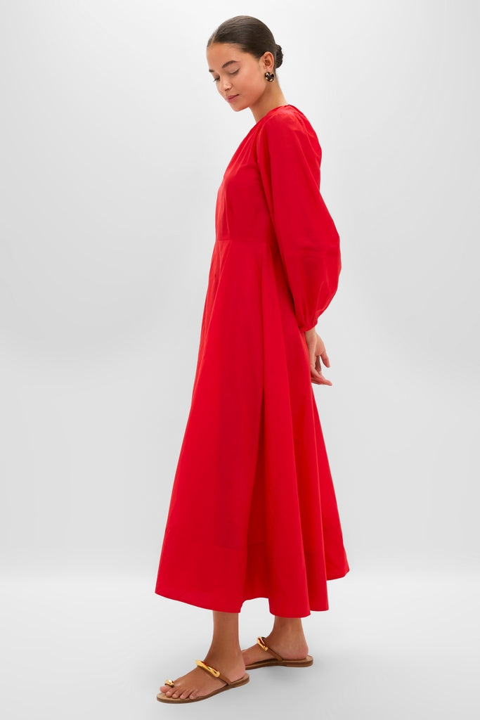 Woman wearing the Tigerlily Bonita Dress, a classic, high-end, flowing red gown with puffed sleeves and A-line skirt, creating an effortless, fun look.