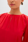 Woman wearing the Tigerlily Bonita Dress, showcasing its gathered-neck and keyhole opening, paired effortlessly with chunky hoop earrings for a classic, high-end look.