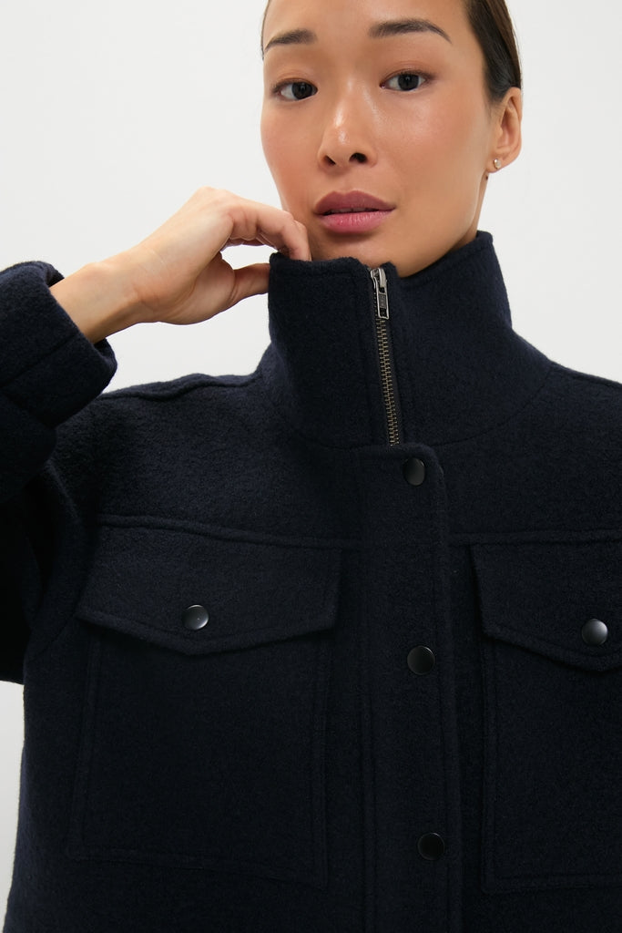 Person wearing the classic Midnight Selva Cropped Bomber, an effortless, high-end wool shacket with a stand-up collar, front zipper, and two chest flap pockets, exuding fun sophistication.