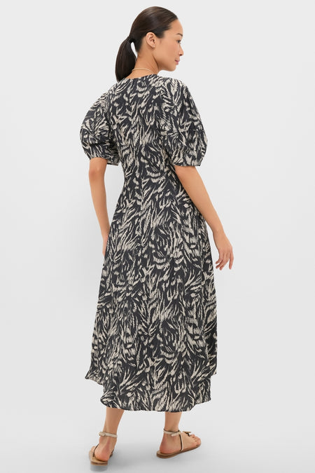 Woman in Abstract Animal Midnight Bettina Maxi dress with classic puff sleeves and flared skirt, embodying effortless high-end style and fun elegance, perfect for confident, versatile wear.
