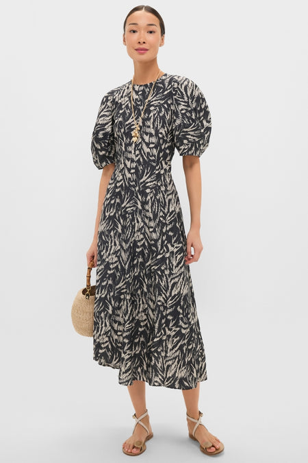 Young woman models the classic Abstract Animal Midnight Bettina Maxi, featuring an effortless brush-stroke print, puffed sleeves, and a fun, high-end flair with a straw handbag.