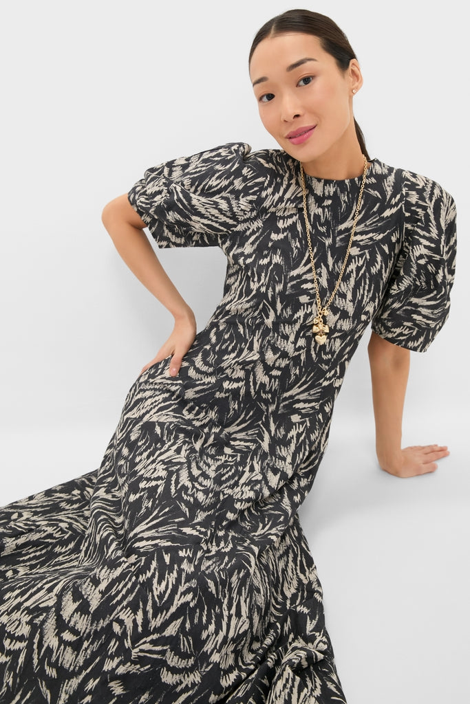 Woman in a classic Abstract Animal Midnight Bettina Maxi dress with puffed sleeves, layered gold necklaces, embodying effortless elegance and fun, high-end style.