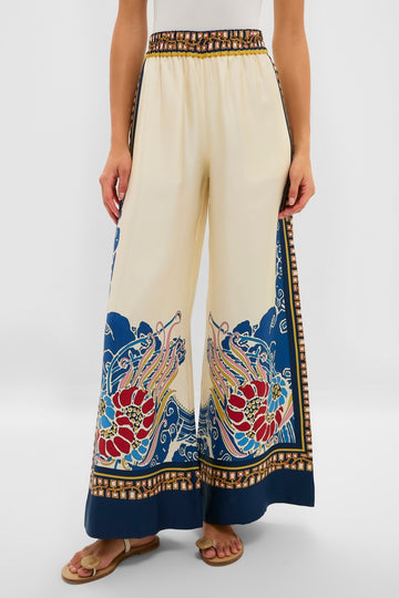 Model showcasing Lemuria Placee Palazzo Pants in a creamy beige with a vibrant floral hem. These high-waisted, wide-leg trousers offer a classic, effortless, and high-end style.