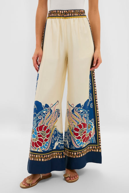 Model showcasing Lemuria Placee Palazzo Pants in a creamy beige with a vibrant floral hem. These high-waisted, wide-leg trousers offer a classic, effortless, and high-end style.