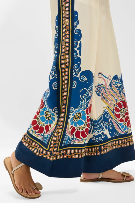 Effortlessly chic Lemuria Placee Palazzo Pants in a classic wide-leg design with bold border print, paired with simple sandals for a fun, high-end look.