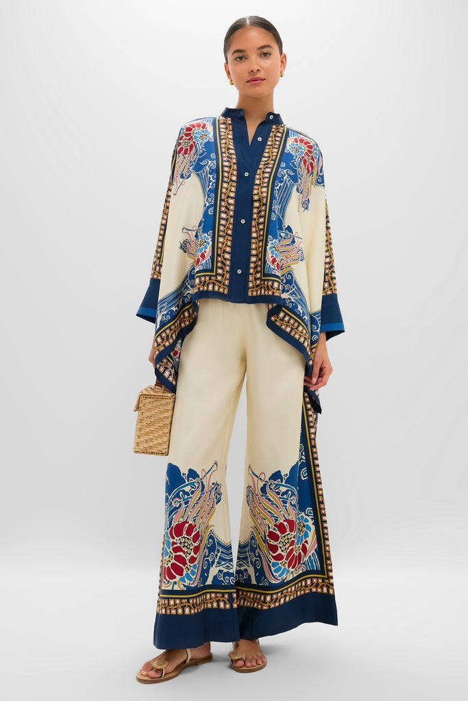 Model wearing Lemuria Placee Palazzo Pants, classic wide-leg trousers with ornate prints, styled with matching blouse and straw bag, for an effortless, high-end look.