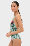 Zooflora One Piece Swimsuit: A classic, effortless halter swimsuit with a tropical print, perfect for a fun and high-end look, worn by a woman in profile.
