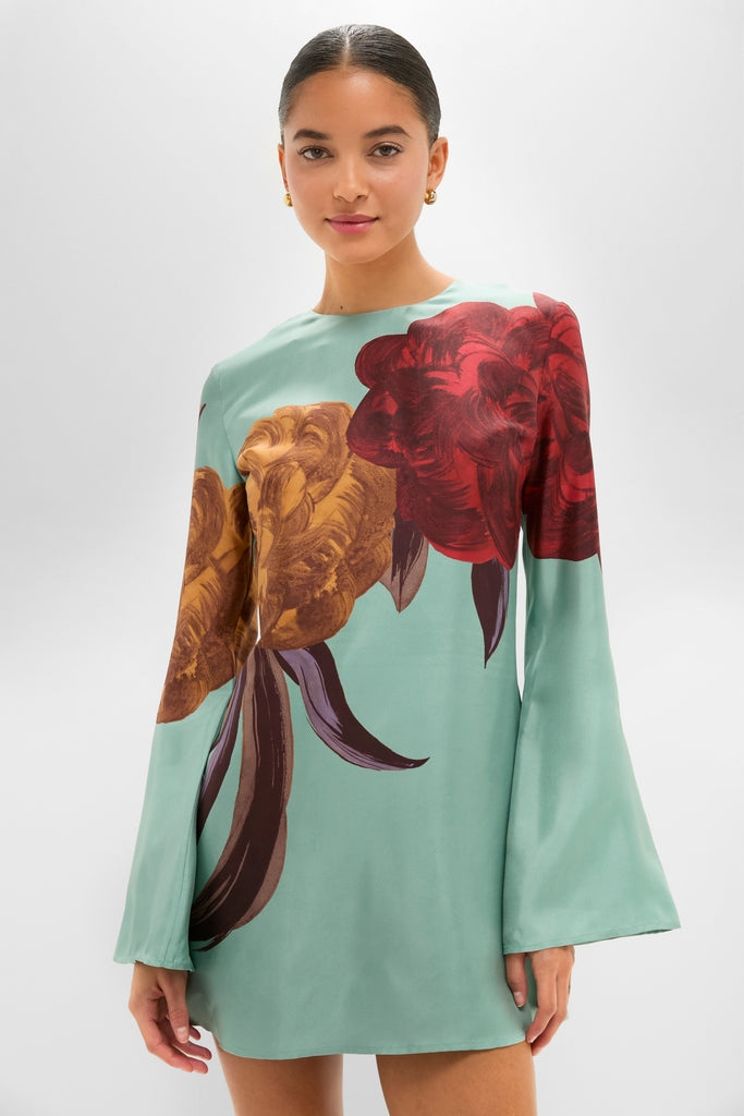 Young woman models the Peony Placee Mini Supremes Swing Dress, a classic and effortless silk shift with bell sleeves and floral prints, embodying high-end fun.