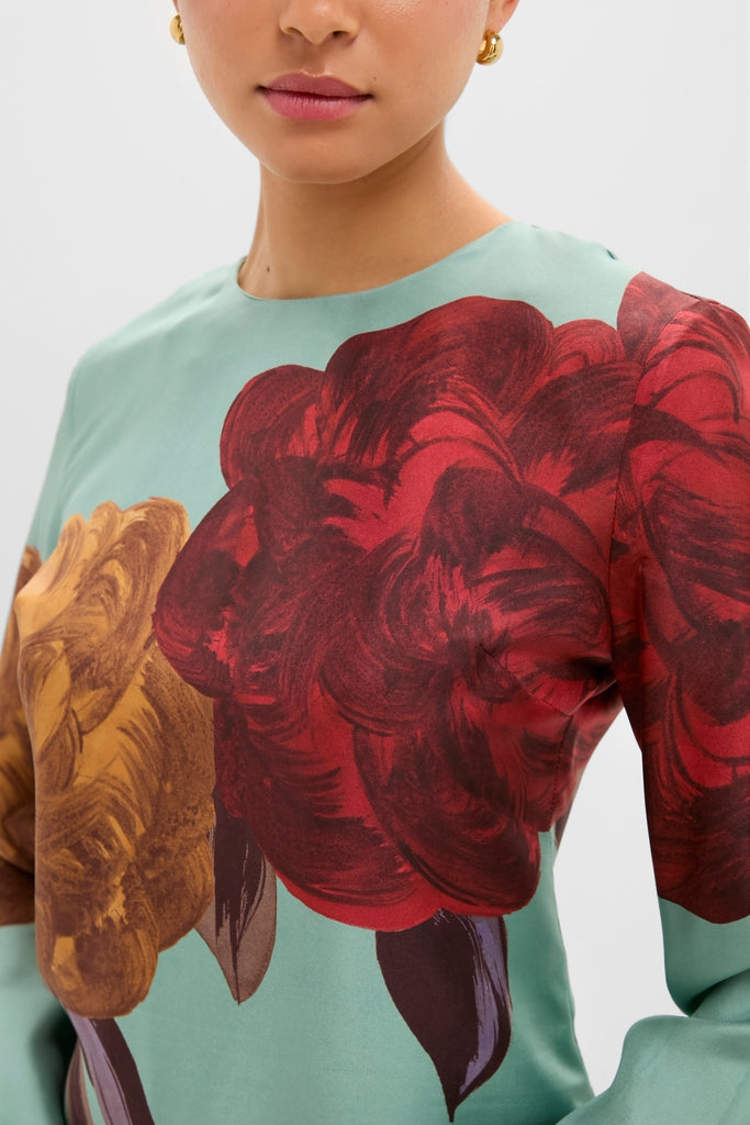 Woman wearing Peony Placee Mini Supremes Swing Dress with painterly roses, showcasing classic, effortless style. The dress features fluted sleeves and an A-line silhouette, exuding fun and high-end appeal.