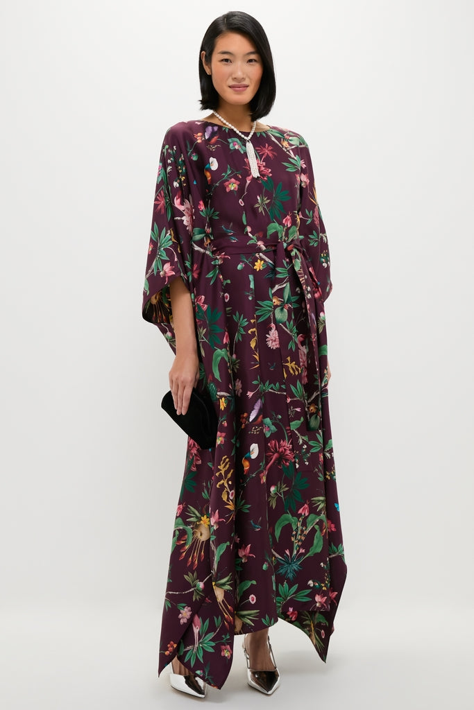 Woman poses in a classic Zooflora Square Kaftan, an effortless, high-end silk dress featuring a fun botanical pattern, kimono sleeves, and a removable waist belt.