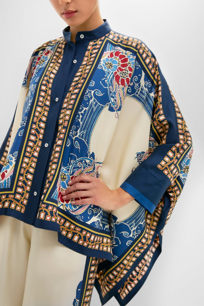 The Lemuria Placee Foulard Shirt showcases a classic, effortless style with its fun, high-end baroque print, drapey sleeves, and mandarin collar in luxurious silk.