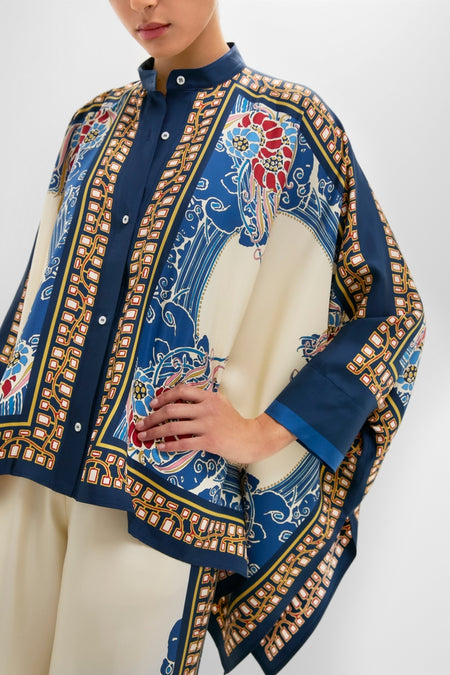 The Lemuria Placee Foulard Shirt showcases a classic, effortless style with its fun, high-end baroque print, drapey sleeves, and mandarin collar in luxurious silk.