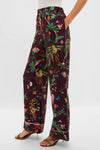 Model wearing Zooflora Pajama Pants with a classic wide-leg silhouette, botanical motif, and elastic waist; paired with strappy sandals, reflecting effortless, high-end style.