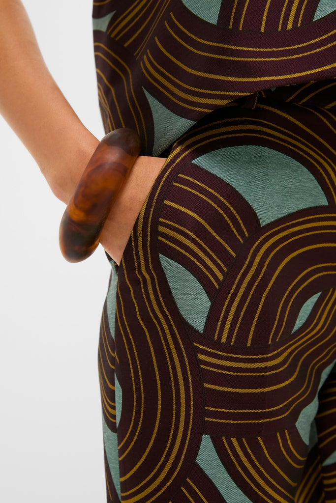 Close-up of a hand in the pocket of classic Montecarlo Jacquard Hendrix Pants, showcasing effortless style and high-end jacquard fabric with a bold, fun print.