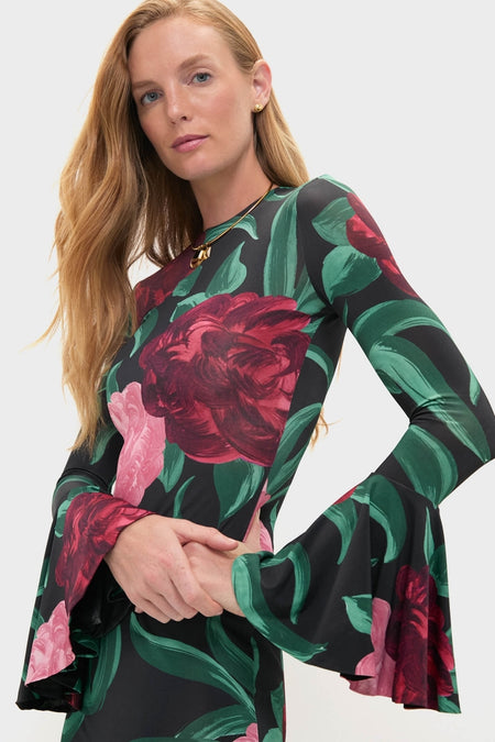 Woman wearing the Peony Alba Dress, a classic, long-sleeve design with red and pink floral patterns, accessorized with a gold necklace and earrings for an effortless, high-end look.