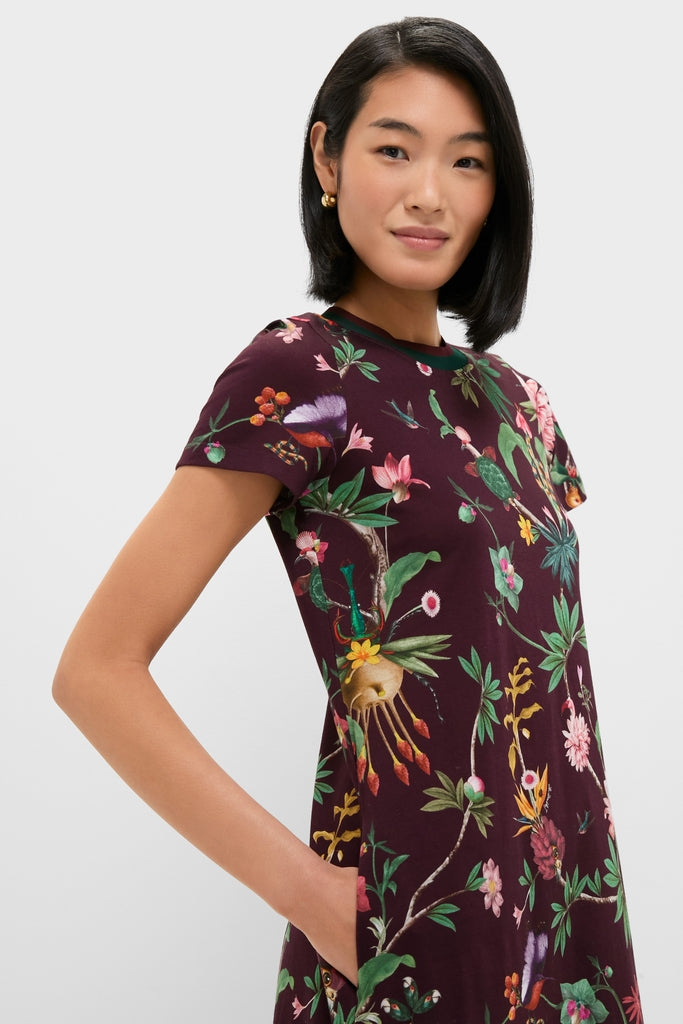 Young woman in a classic Zooflora Sporty Swing Dress with a botanical print, showcasing effortless style with gold hoop earrings and side pocket detail.