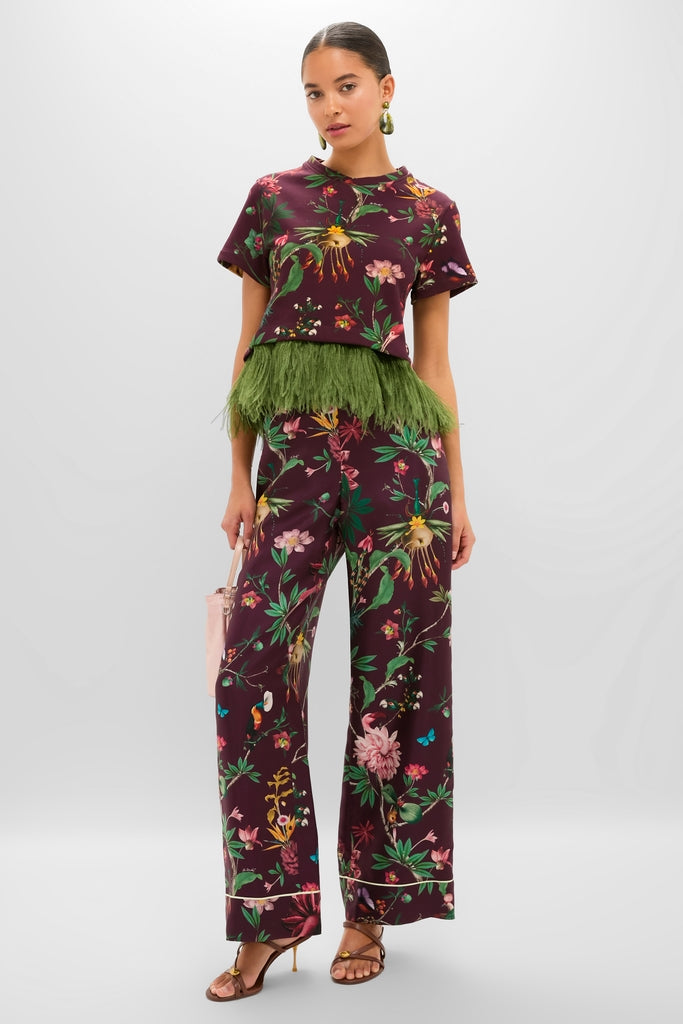 Model wearing the classic Zooflora La Scala Tee with Feathers and matching pants, accessorized with a pink bucket handbag and strappy heels, exuding effortless high-end style.