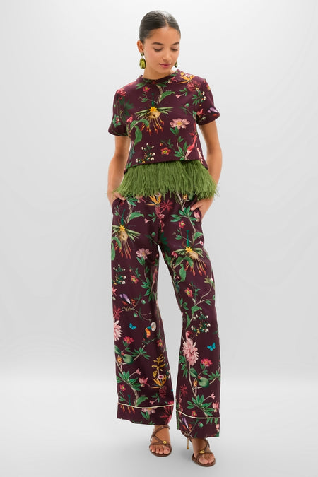 Woman models the Zooflora La Scala Tee with Feathers, showcasing a classic, effortless, high-end look with a cropped, boxy silhouette and feather hem, paired with matching trousers.