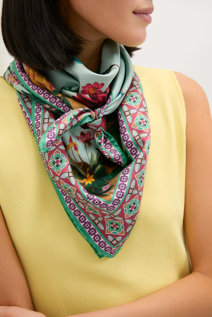 Zooflora Placee Foulard 90x90 Scarf in vibrant print, effortlessly worn around the neck over a sleeveless top, showcasing classic, high-end Italian style.