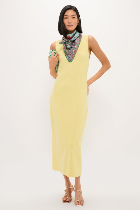 Model showcases the Zooflora Placee Foulard 90x90 Scarf, a classic, effortless piece perfect for versatile, fun styling; paired with a pale yellow dress and sandals.