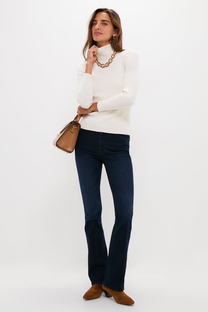 Woman wearing Karaoke in Kyoto The Mid Rise Smokin Skimp jeans, pairing effortlessly with a classic white turtleneck and chic accessories for a high-end, fun look.