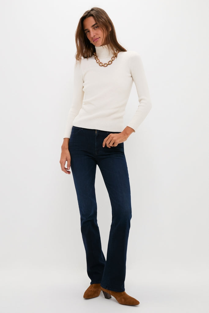 Model in a classic, effortless style wearing the Karaoke in Kyoto The Mid Rise Smokin Skimp jeans paired with a white turtleneck and high-end accessories.