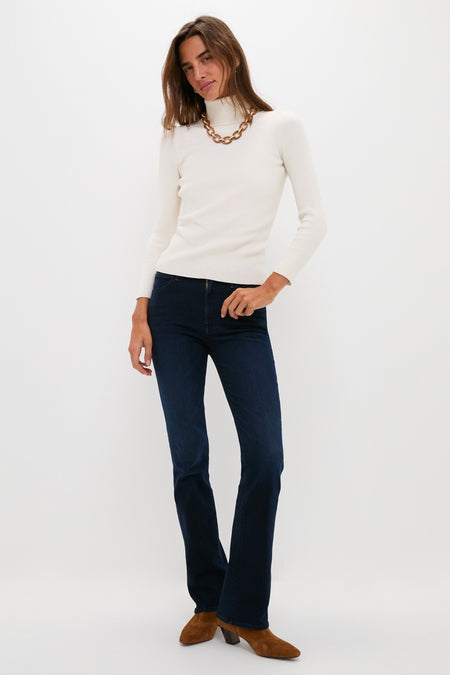 Model in a classic, effortless style wearing the Karaoke in Kyoto The Mid Rise Smokin Skimp jeans paired with a white turtleneck and high-end accessories.