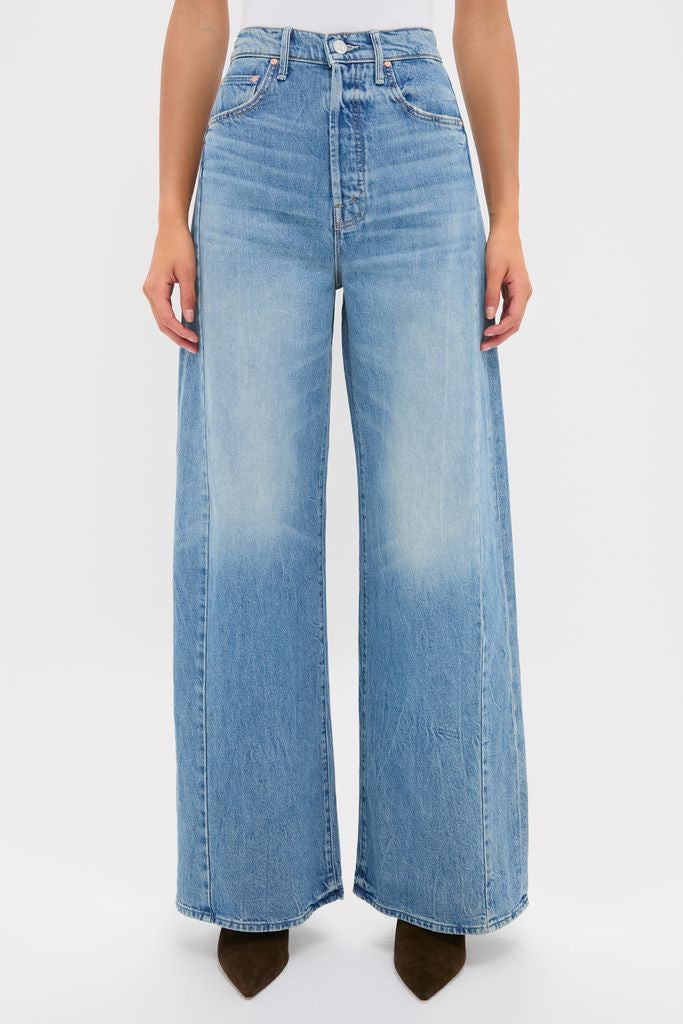 Person wearing Folk Star The Pipe-Dream Button Sneak jeans, showcasing classic, effortless high-waisted denim with ultra-wide legs and dark, pointed-toe boots for a fun, high-end look.