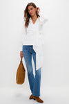 Woman in classic Hokey Pokey The Outsider Sneak jeans, effortlessly styled with a white wrap blouse and brown suede accessories for a fun, high-end look.