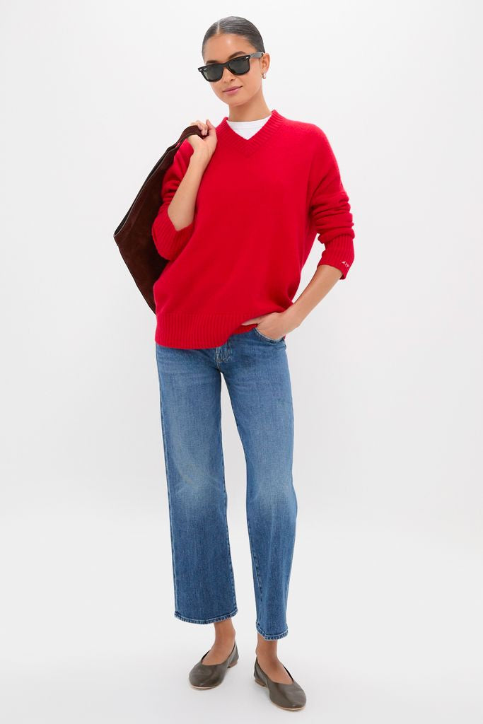 Woman in black sunglasses wearing Tambourine Man The Mid Rise Rambler Zip Ankle jeans, styled with a red sweater, showcasing a classic, effortless, high-end look.