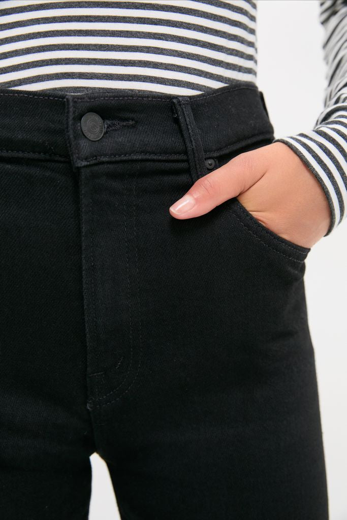 Model wearing the Nighty Night The Kick It: a classic, effortless black-and-white striped top tucked into high-waisted black jeans, showcasing a high-end, fun style.