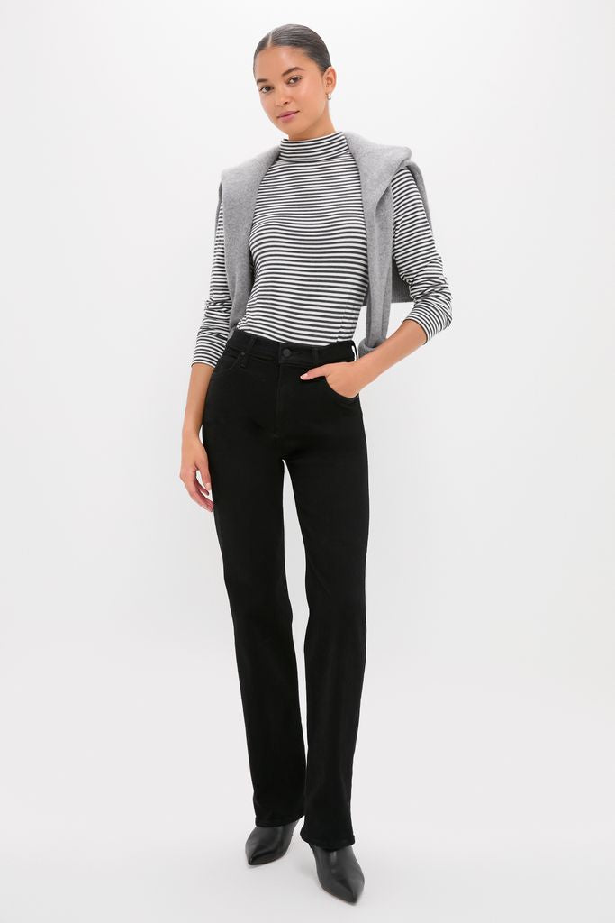 Young woman models the Nighty Night The Kick It outfit—classic, effortless, and high-end—featuring a striped mock-neck top, high-waisted trousers, and stylish pointed-toe ankle boots.