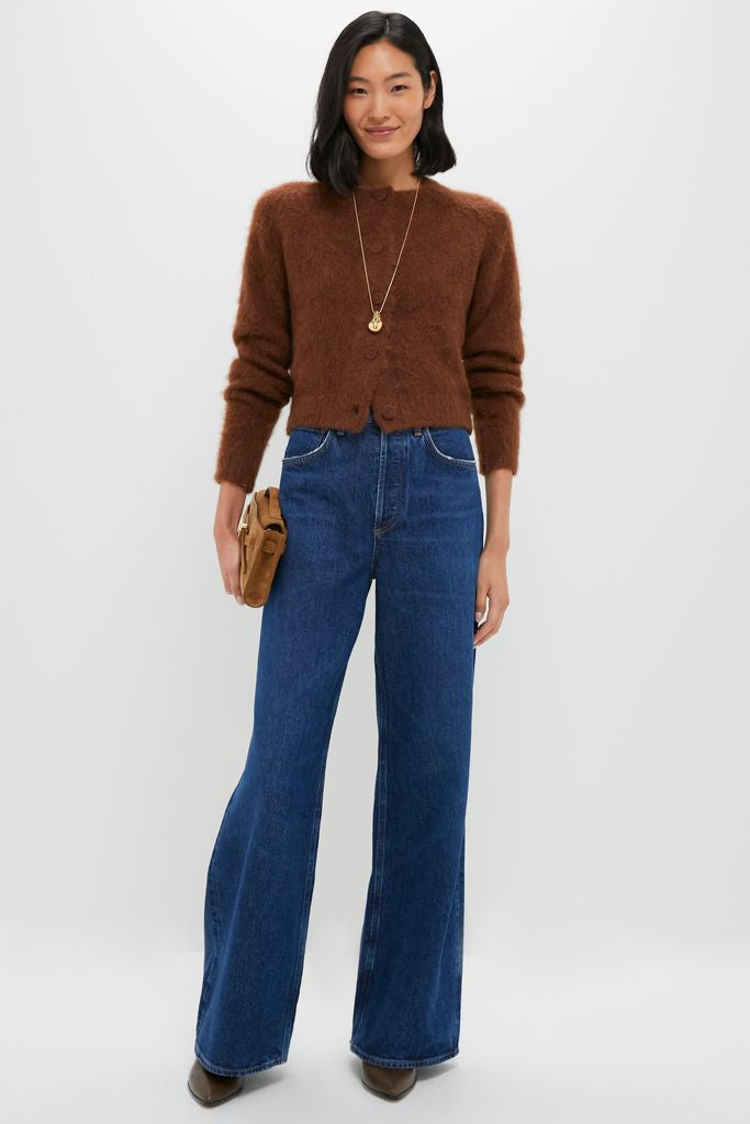 Model wearing the Gold Betty Necklace, a classic, high-end accessory, with a sculptural pendant, paired with an effortless cardigan and fun, wide-leg jeans for a versatile look.