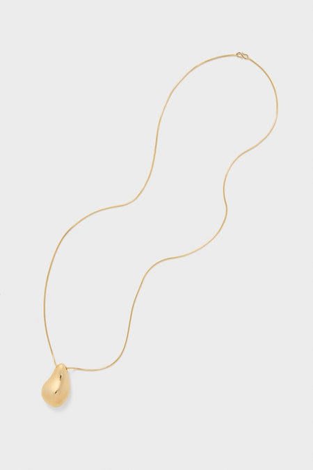 Gold Betty Necklace with a classic, asymmetrical bean-shaped pendant on a fine chain, embodying effortless luxury and high-end style for versatile, fun, and modern wear.