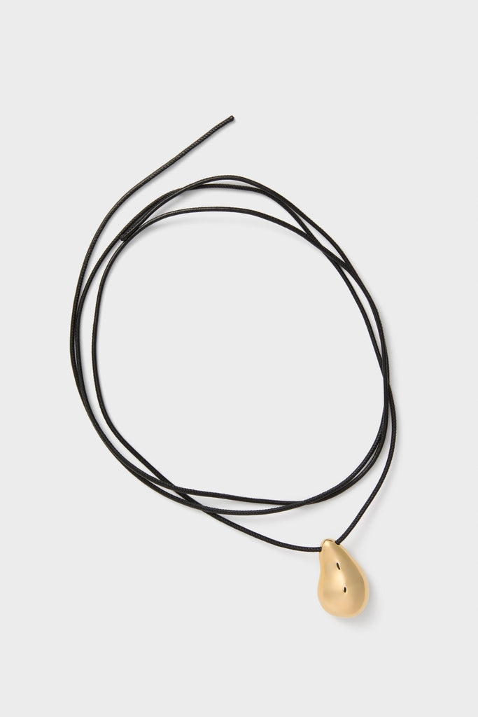 Gold Betty Necklace: A classic, high-end piece featuring an effortless teardrop-shaped gold pendant on a thin black cord, embodying fun and understated luxury.