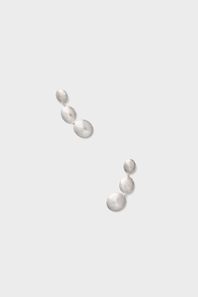 Silver Ruby Earrings: Classic drop earrings featuring three spiral-patterned discs in a silver-tone finish, exuding an effortless, fun, and high-end charm. Perfect for any chic ensemble.