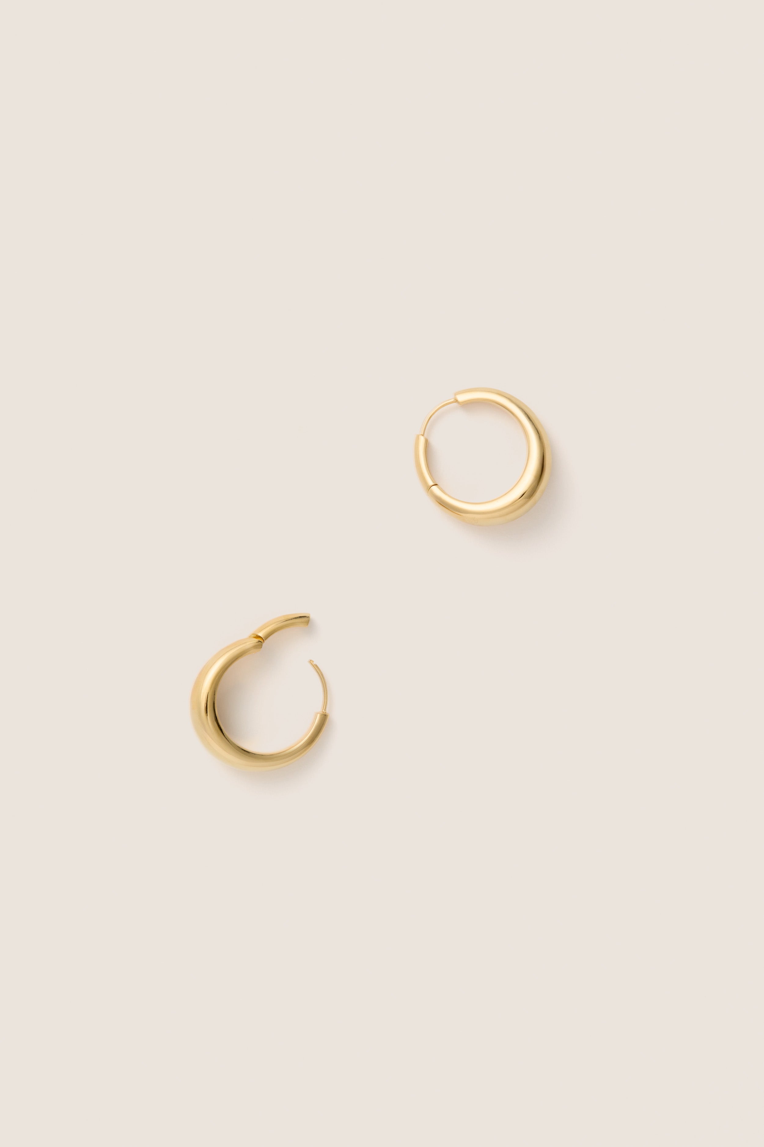 Gold Andrea Earrings: Classic, chunky gold-tone hoops exude effortless elegance, perfect for elevating any look with high-end appeal. A fun, versatile accessory for any wardrobe.